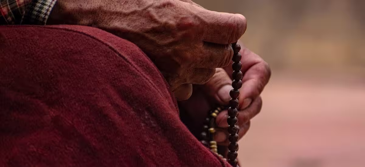 Hands holding a row of prayer beads