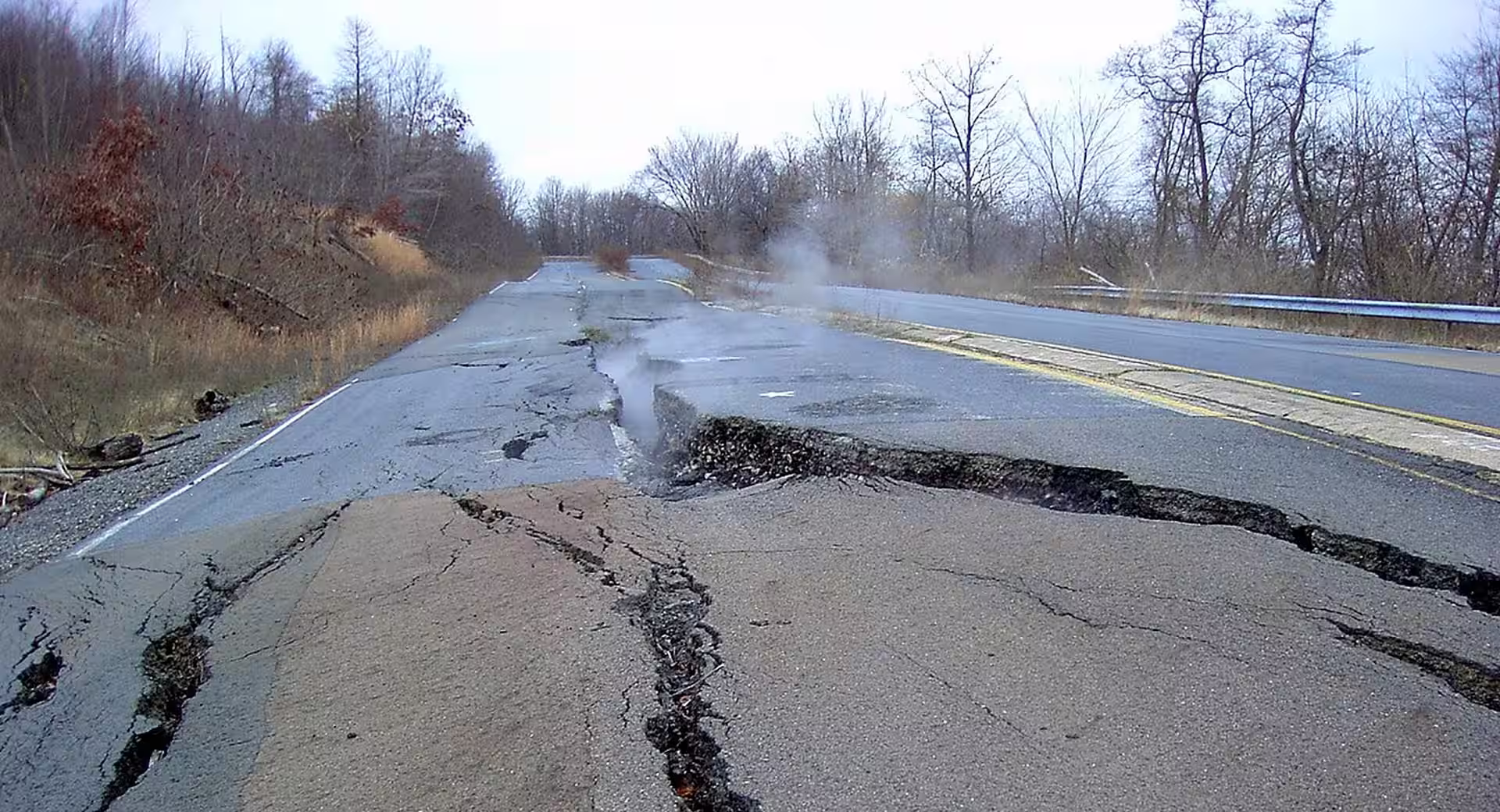 Cracked road in Centralia Pennsylvania with smoke rising from the underground mine fire burning since 1962